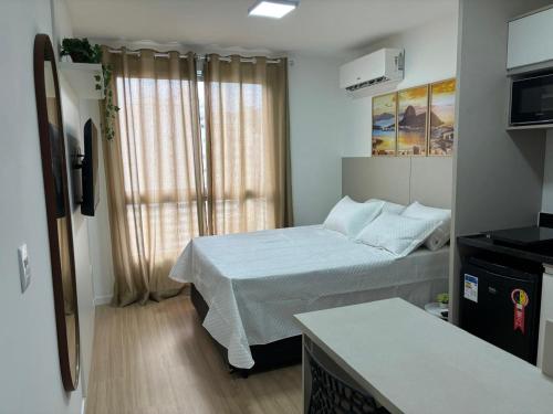 a small room with a bed and a window at Loft Boa Viagem - Uni Studios in Niterói