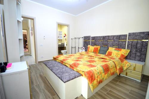 Un dormitorio con una cama grande con almohadas naranjas. en أبراج الداون التاون سيتي ايدج العالمين الجديده, en Dawwār Abū Maḩrūs