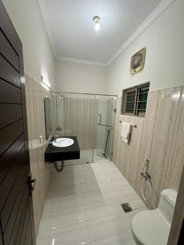 a bathroom with a sink and a shower and a toilet at Family Cottage Islamabad in Islamabad