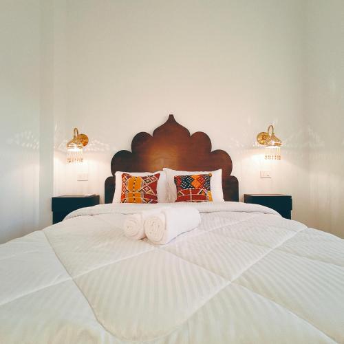 a bedroom with a large white bed with towels on it at Arabic Apartment in Safaga