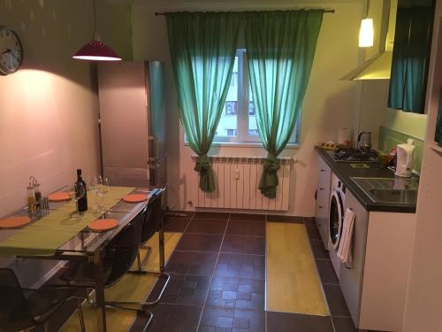 a kitchen with a table and a window with green curtains at New Central Roof top view in Bucharest