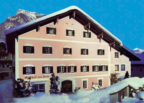 um grande edifício com neve no telhado em Gasthof zur Post em Sankt Martin bei Lofer