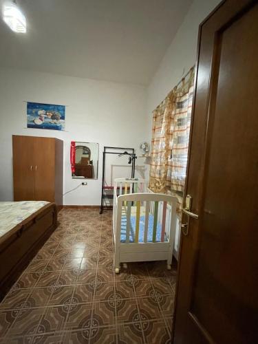a bedroom with a bed and a crib in it at Apartment Su Cramu in Villacidro