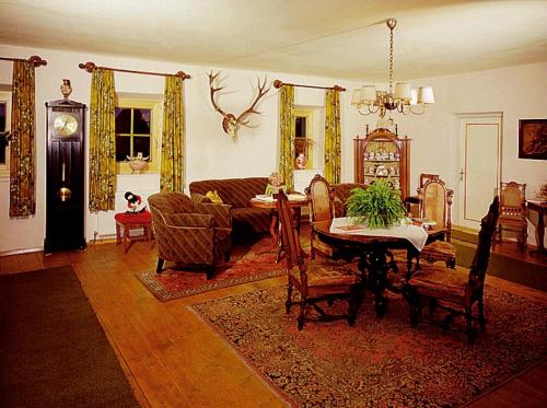 a living room with a couch and a table and chairs at Gasthof zur Post in Sankt Martin bei Lofer