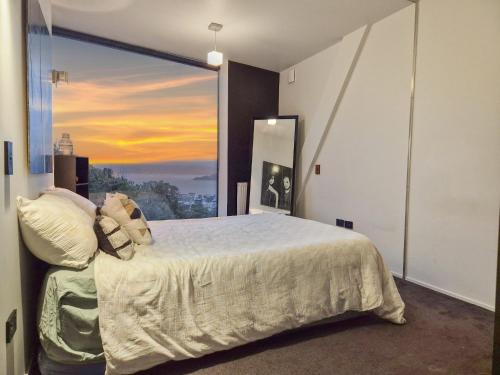 a bedroom with a bed and a large window at Luxury Wellington Accomodation in Wellington