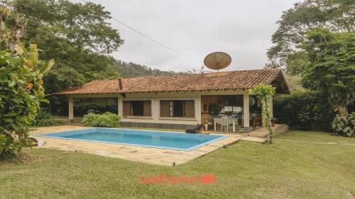 a house with a swimming pool in the yard at Sitio em Teresópolis com Piscina e Churrasqueira in Teresópolis