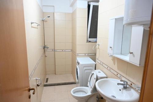 a small bathroom with a toilet and a sink at Vacation Apartments - Shengjin in Shëngjin
