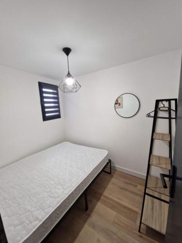 - une chambre avec un lit, une échelle et un miroir dans l'établissement La Porte de la Mer, à Port-la-Nouvelle