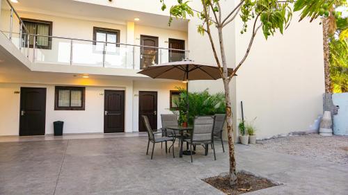 a patio with a table and chairs and an umbrella at Hotel Loreto Palmar in Loreto