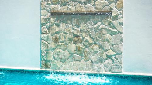 a stone wall next to a swimming pool at Hotel Loreto Palmar in Loreto