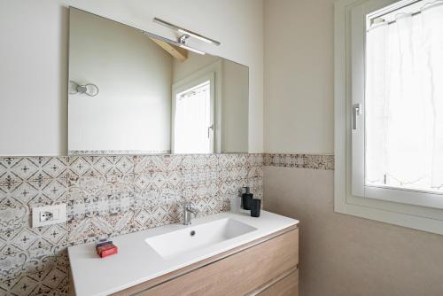 a bathroom with a white sink and a mirror at Ca' Mia - Casa Belfiore in Vicenza