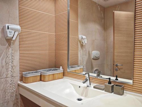a bathroom with a sink and a mirror at Garsoniera Rin Grand in Bucharest
