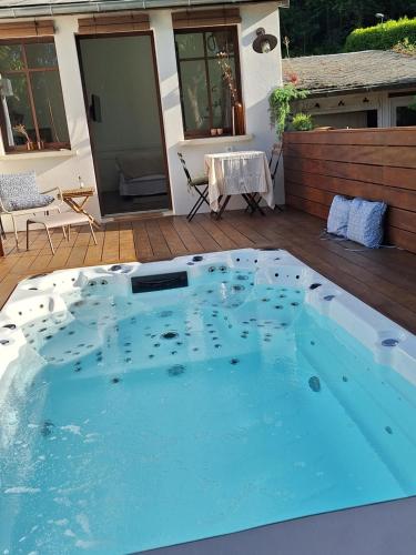 - une grande piscine sur une terrasse avec une table dans l'établissement Studio de charme et spa de nage, à La Celle-sous-Gouzon