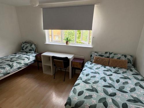 a bedroom with a bed and a desk and a window at Amazing New Bed Stay in New Cross Goldsmiths in London