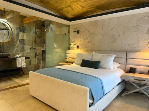 a bedroom with a large bed and a bathroom at Hotel Boutique Casa Laja in San Miguel de Allende