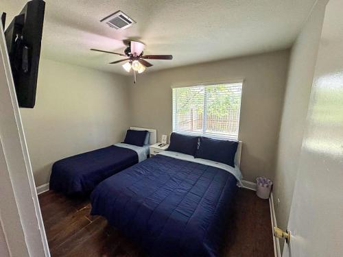 a bedroom with two beds and a ceiling fan at Cozy Stay in Bryan, TX in Bryan