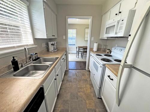 a kitchen with white cabinets and a sink at Cozy Stay in Bryan, TX in Bryan