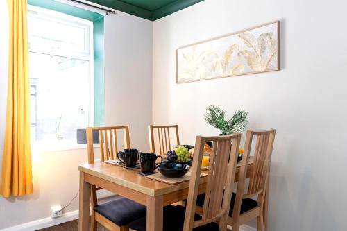 a dining room with a table and chairs and a window at The Storybook Stay in Guisborough