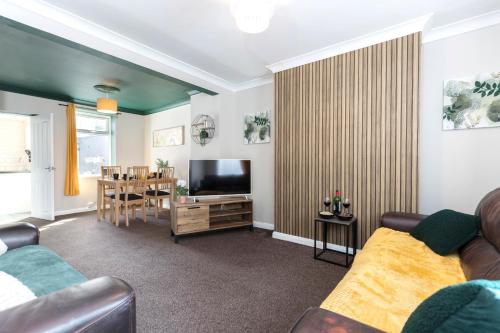 a living room with a couch and a television at The Storybook Stay in Guisborough