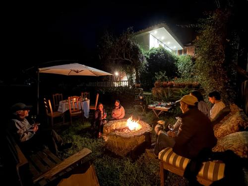 a group of people sitting around a fire pit at night at Casa Jazmín Hospedaje Familiar Eco Amigable - Huayoccari, Sacred Valley in Huayoccare