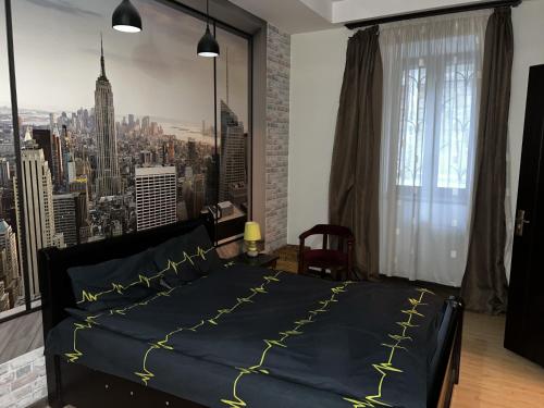 a bedroom with a black bed with yellow writing on it at Solo Apartment in Tbilisi City