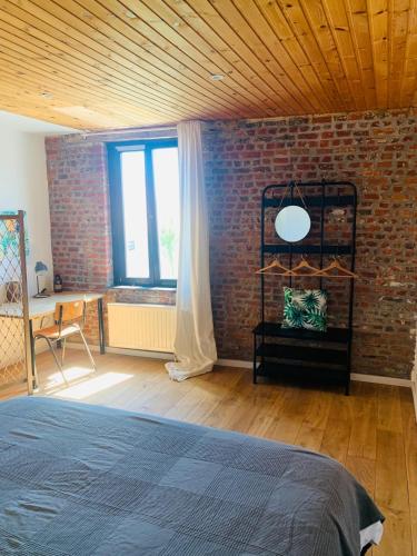 a bedroom with a brick wall and a bed at Little Farm Comfort&PrestigeHouse in Ittre