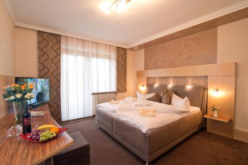 een hotelkamer met een groot bed en een televisie bij Dreilandhof in Loipersdorf bei Fürstenfeld