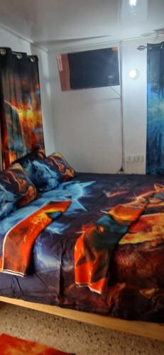 a bed with a colorful comforter in a room at Entire 3 bedrooms in Saint Thomas Jamaica fully air-conditioning in Port Morant