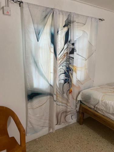 a bedroom with a white curtain next to a bed at Entire 3 bedrooms in Saint Thomas Jamaica fully air-conditioning in Port Morant
