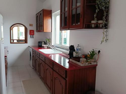 a kitchen with a red counter top and a sink at Dutra's House in Horta