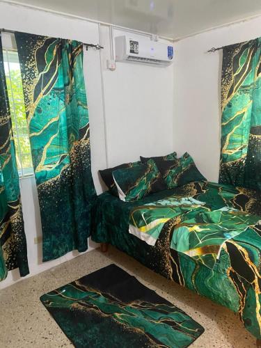 a bedroom with a bed and a window with curtains at Entire 3 bedrooms in Saint Thomas Jamaica fully air-conditioning in Port Morant
