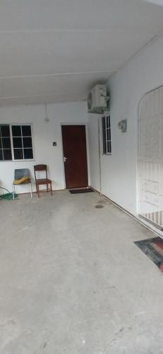 an empty room with a door and a chair at Entire 3 bedrooms in Saint Thomas Jamaica fully air-conditioning in Port Morant