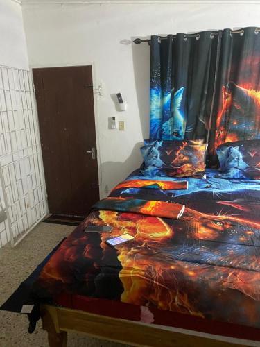 a bedroom with a bed with a colorful comforter at Entire 3 bedrooms in Saint Thomas Jamaica fully air-conditioning in Port Morant