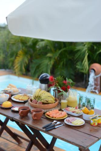 ein Tisch mit Tellern voller Speisen und Getränken in der Unterkunft Vila Orun Pousada in Barreirinhas