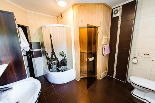 a bathroom with a toilet and a shower and a sink at Cottage Prestige in City Centre & dom4 in Grodno
