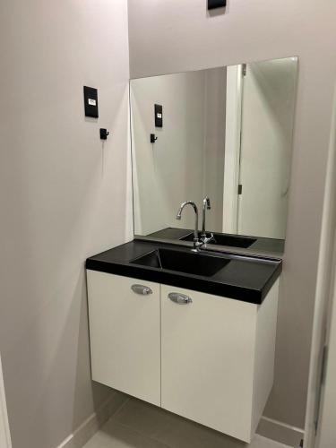 a bathroom with a sink and a mirror at APARTAMENTOS BORA BORA II vila nova 600 METROS DA EXPOVILLE in Joinville