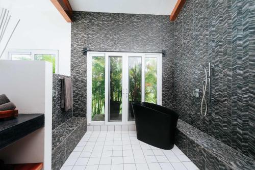 a bathroom with a shower and a black wall at Horizonte Luxe Villa 3BR Infinity & Indoor Pool in Pedasí Town
