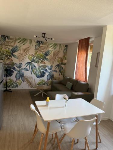 un salon avec une table et un canapé dans l'établissement Mélissa - Lumineux, moderne - Gare - WiFi - Stream, à Homécourt