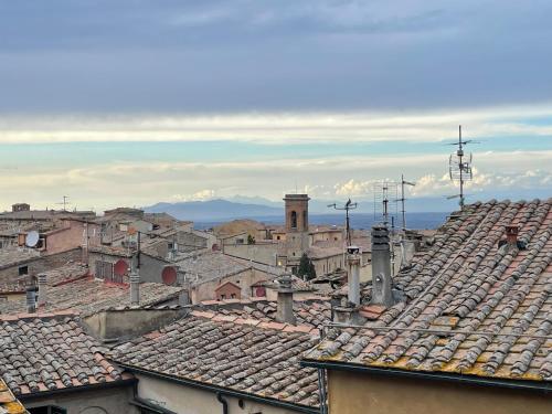 a view of roofs of a city with mountains in the background at Casa Castello in Volterra