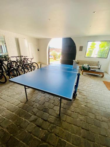 a ping pong table in a room with bikes at Little Farm Comfort&PrestigeHouse in Ittre