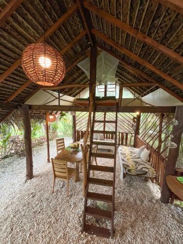 a room with a bunk bed and a table and a ladder at Fare Tearenui - Tu'i'anina Village Huahine in HUH