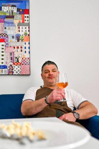 a man sitting at a table with a glass of wine at Vieste Rooftop - Sea view near Pizzomunno - Free private Parking in Vieste