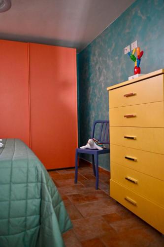 a bedroom with a bed and a dresser and a chair at Vieste Rooftop - Sea view near Pizzomunno - Free private Parking in Vieste