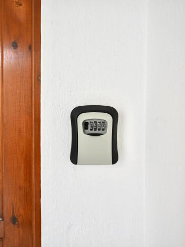 a black and white wall clock on a white wall at Panos Apartment in Kontokali