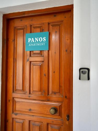 a wooden door with a sign on it at Panos Apartment in Kontokali