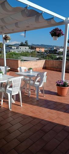 a white table and chairs on a patio with an umbrella at F.A.M. ROOMS in Ciampino