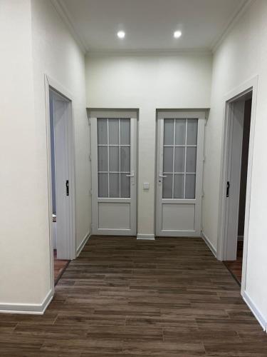 an empty room with two doors and a wooden floor at Vəndam villas in Vǝndam