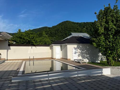 a house with a swimming pool in front of a building at Vəndam villas in Vǝndam