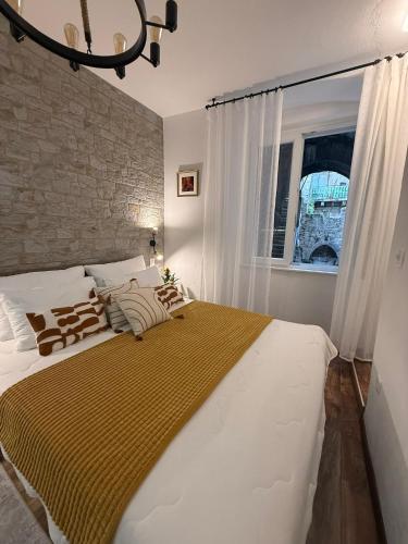 a large white bed in a bedroom with a window at Diokletian's Golden Nest in Split