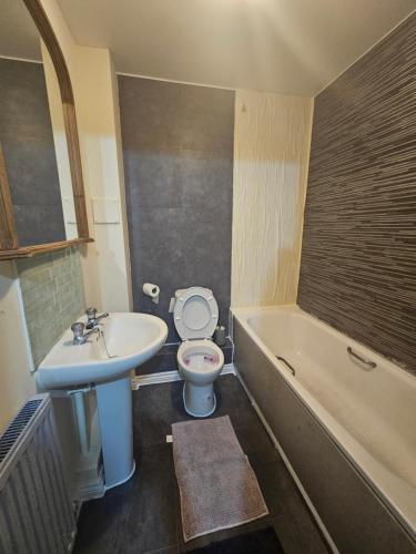 Un baño con lavabo, inodoro y bañera. en Unique stay, en Waltham Cross
